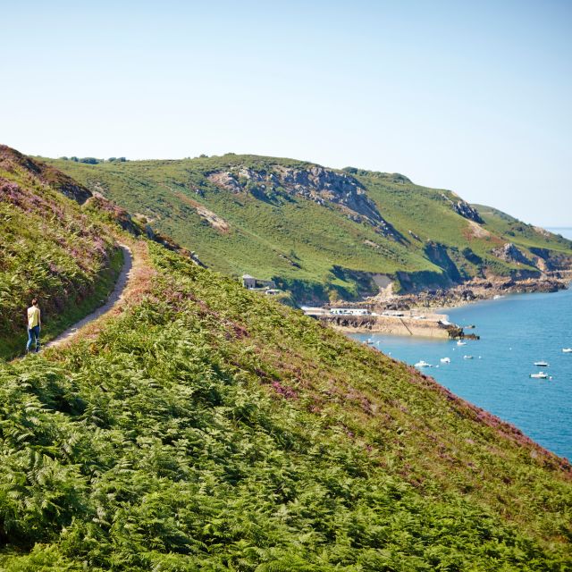 Two people walking on the north coast cliff paths in Jersey in the Channel Islands