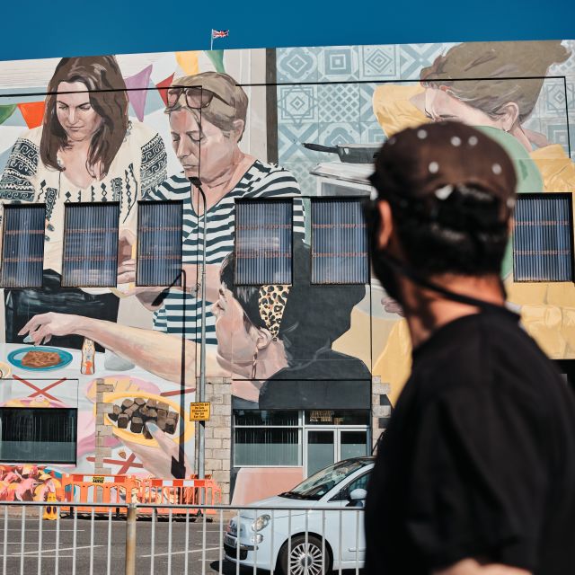 Artist standing in front of mural