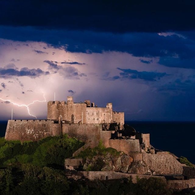 Historic castle at nighttime in lightnight strike
