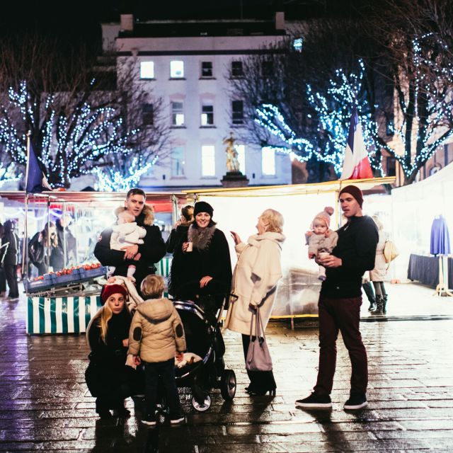 Family at a Christmas market with twinkling lights