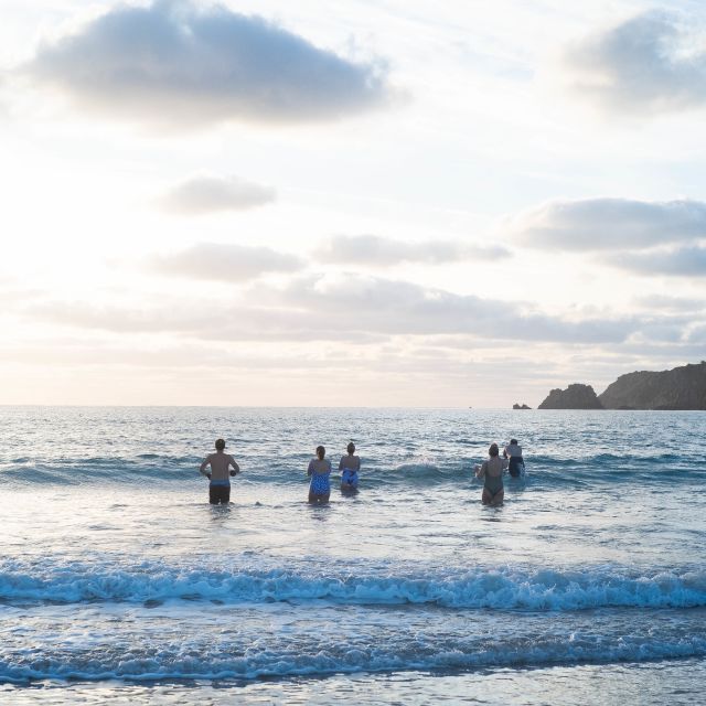 Group of people walking into the sea in winter