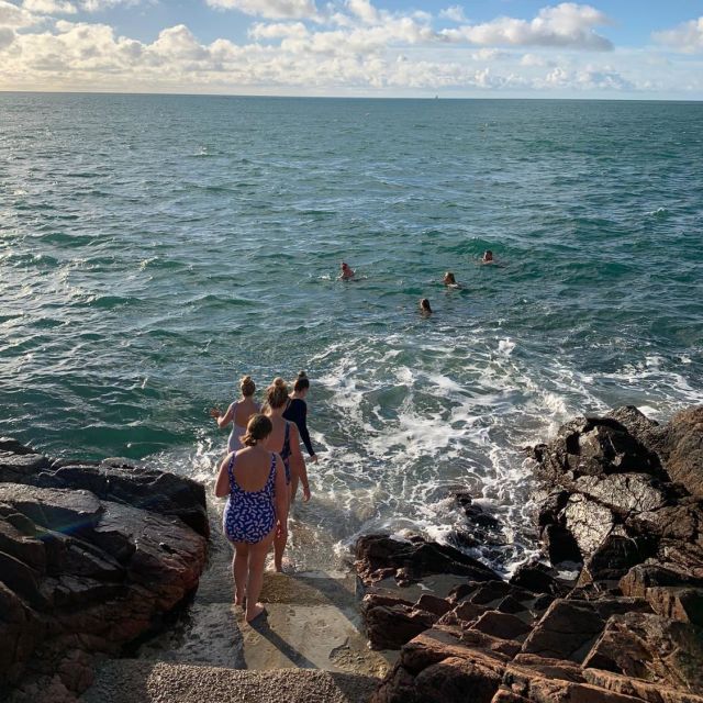 Girls walking down steps into the sea.