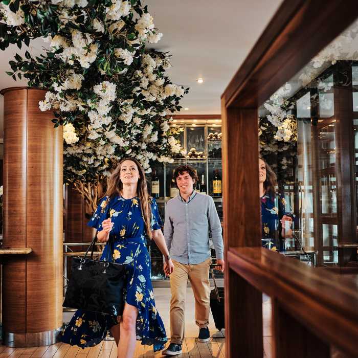 A couple walking into The Club Hotel