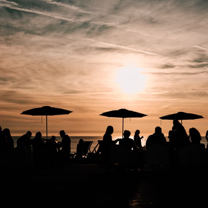 sunset in St. Ouen's Bay with a group of people silhouetted enjoying the evening.