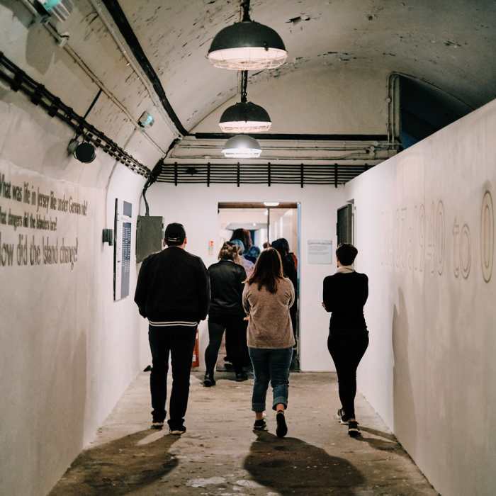 A group of people walking through the Jersey War Tunnels