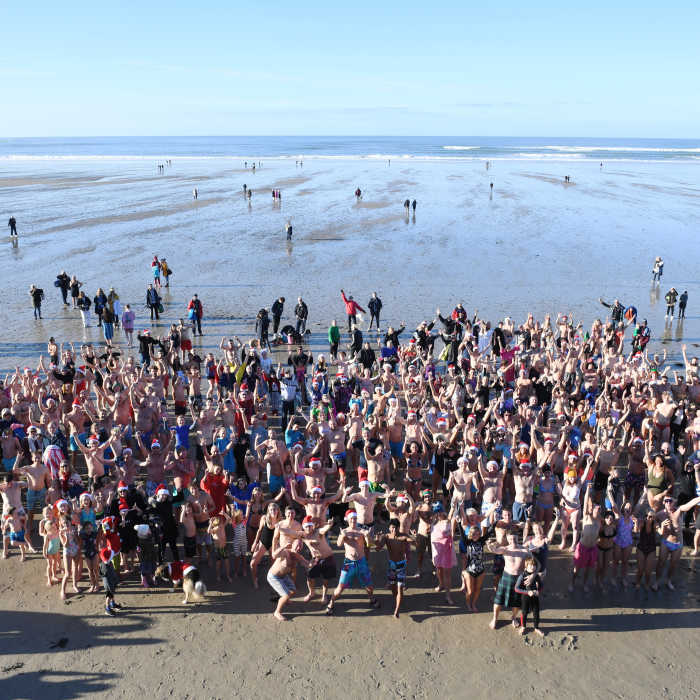 A crowd of people on St Ouen's beach aking part in the Christmas Day Swim