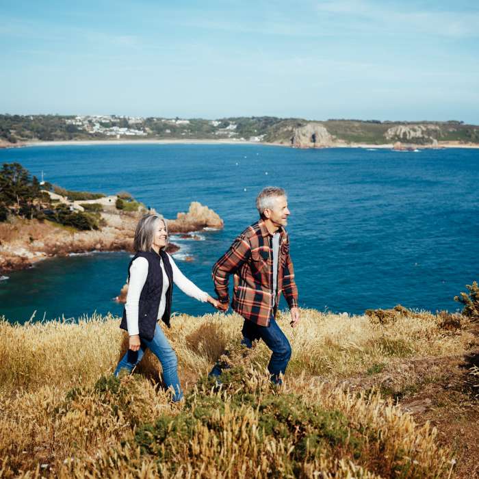 Couple walking on a cliff path above the sea