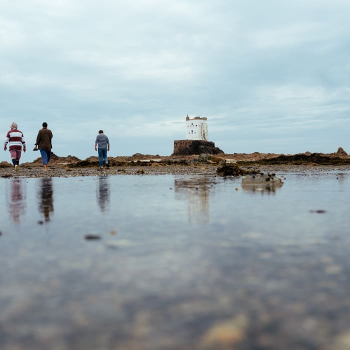 Walking at low tide near a historic tower