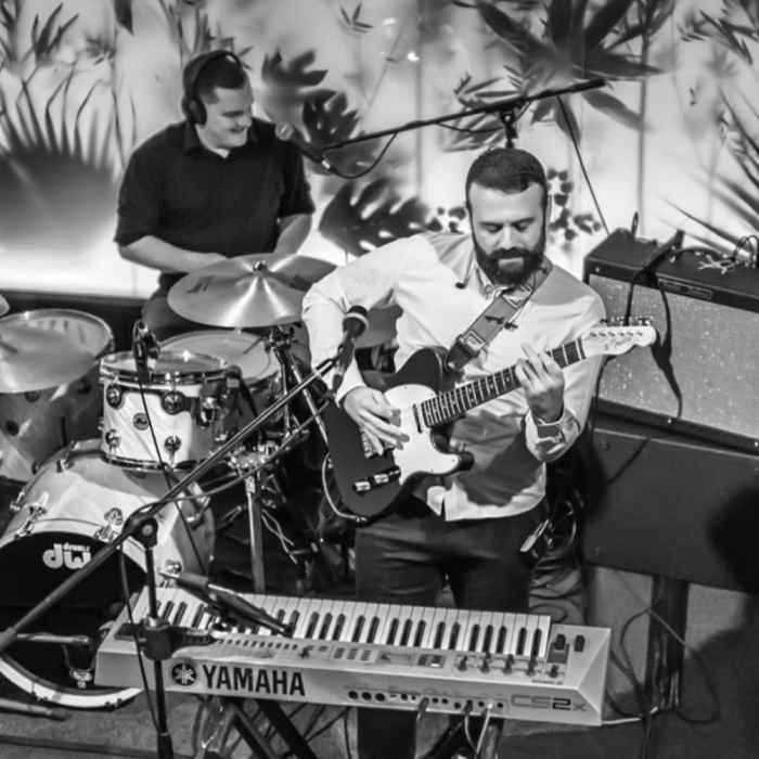 A guitarist and drummer playing in a bar in Jersey