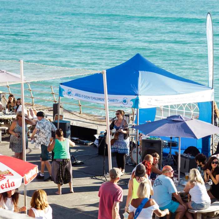 A tent on the St. Ouen's Bay promenade. There is a musician playing inside.