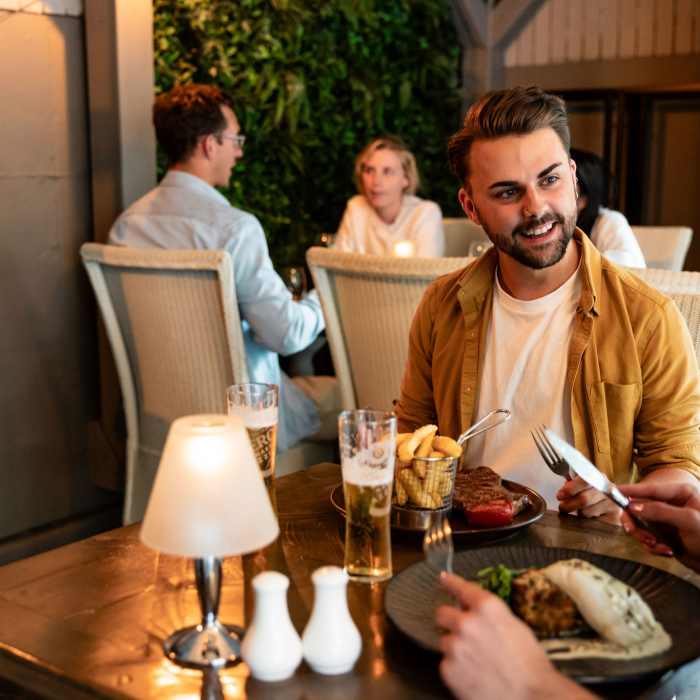 Couple enjoying a meal in front of the fire at Rozel Pub and Dining, Jersey