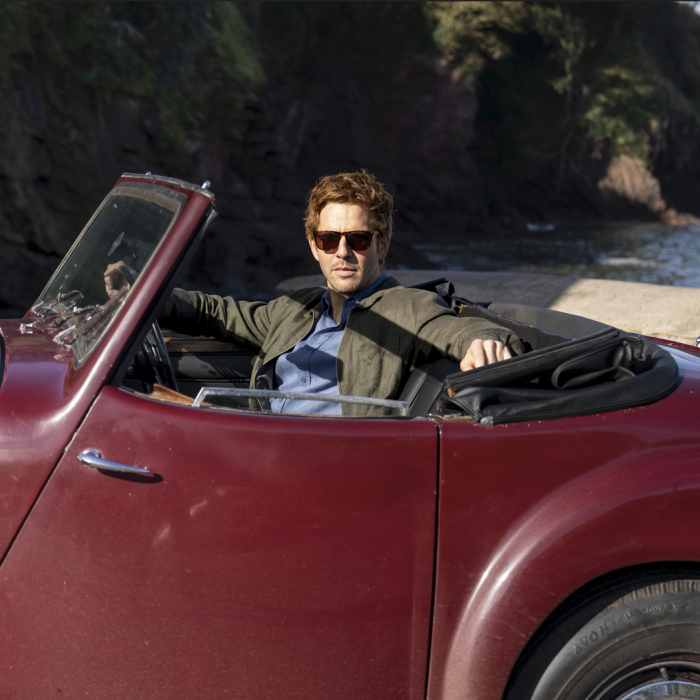 Bergerac star Damien Molony poses in the burgundy Triumph Roadster which appeared in the original Bergerac series